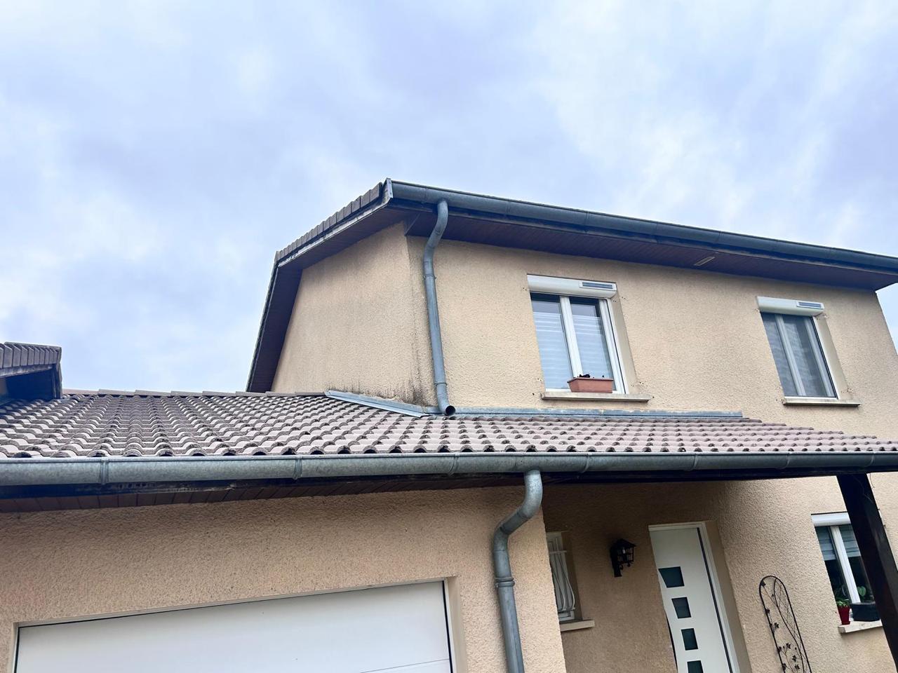 Avant travaux - Toiture pavillonnaire avec anciennes tuiles ternes, gouttières en zinc usées et traces de coulures noires sur la façade