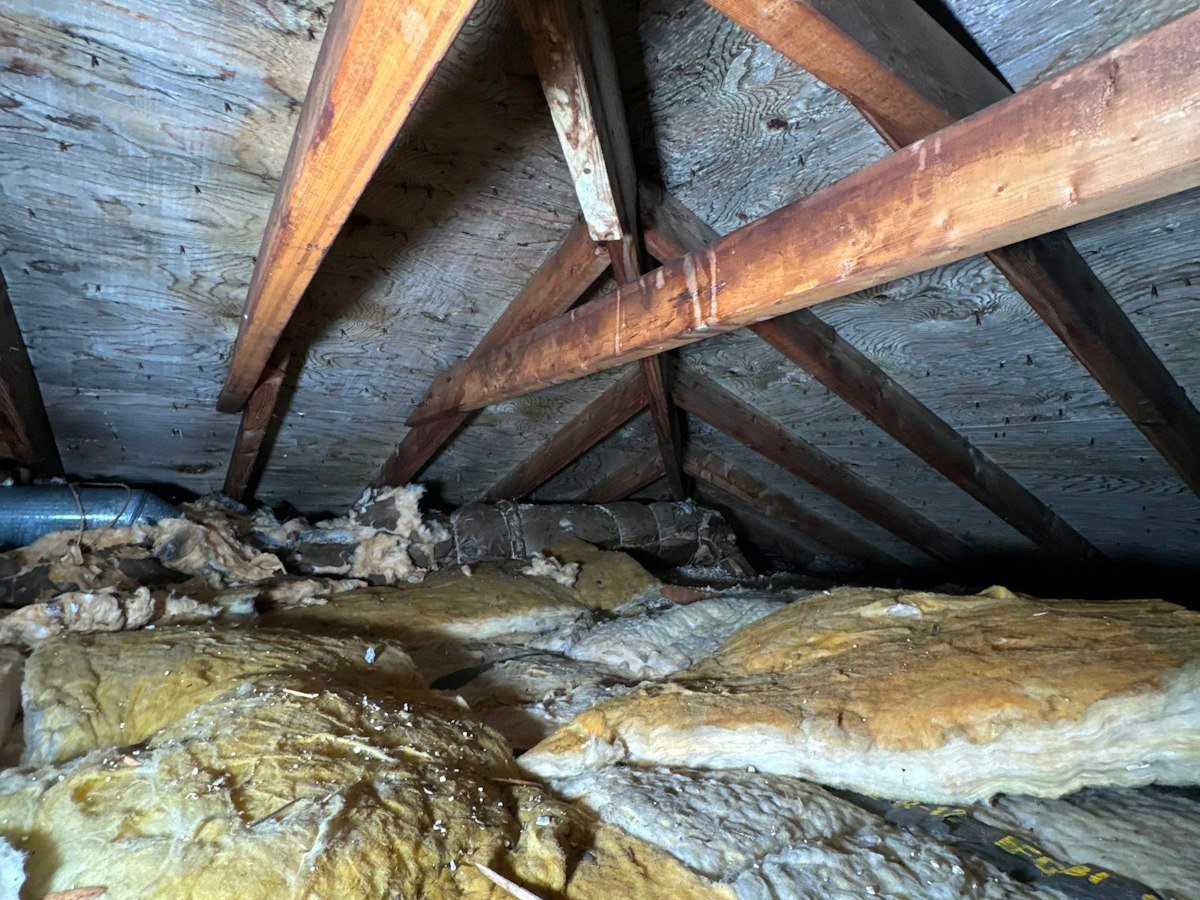 Ancienne isolation tassée dans des combles, par où la chaleur s'échappe